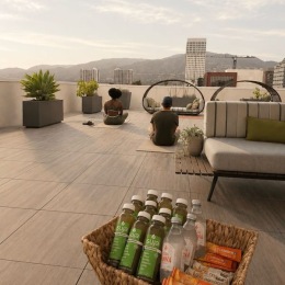 people doing yoga on a patio with a couch and drinks in a basket