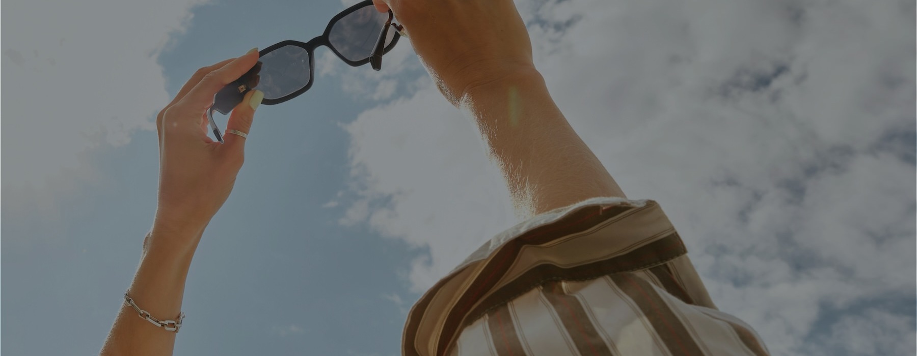 a pair of hands holding sunglasses