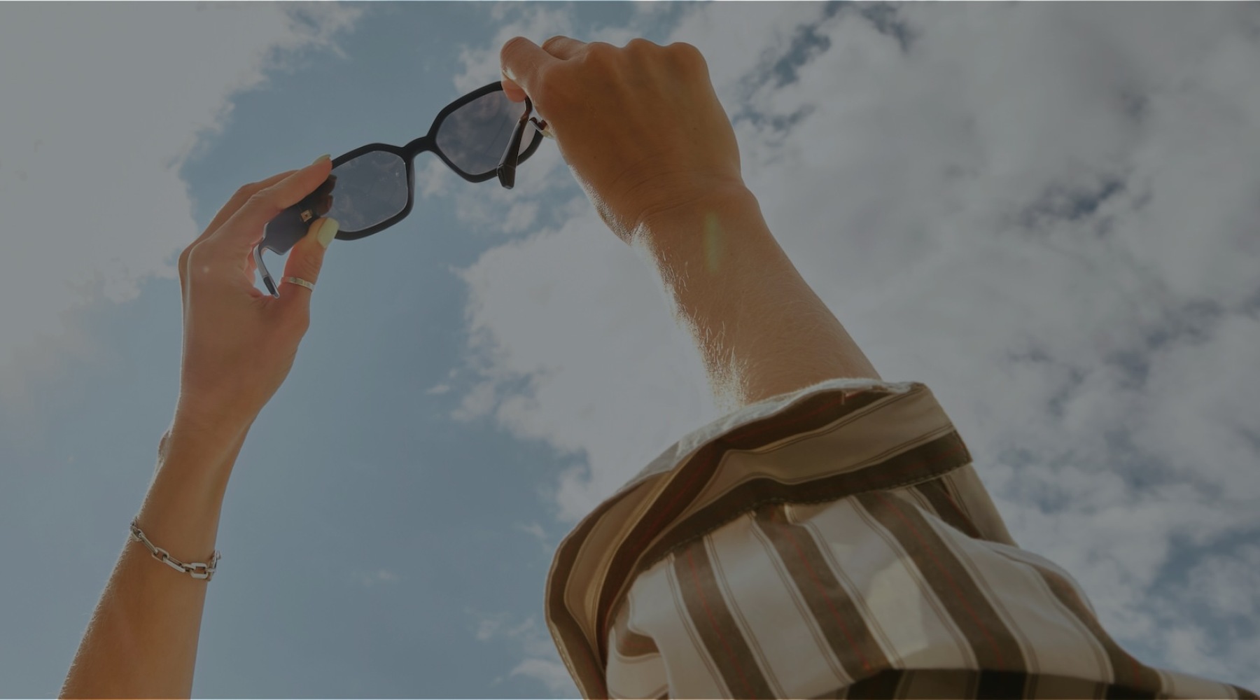 a pair of hands holding sunglasses