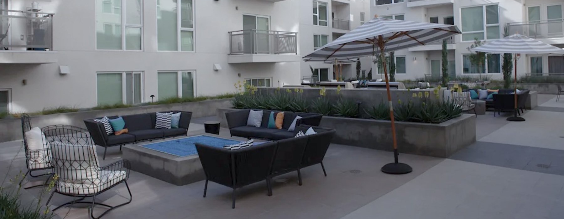 a courtyard with couches, tables and chairs